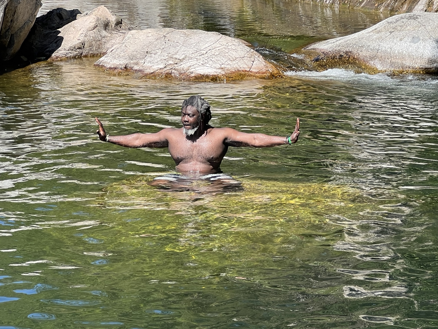 Laye Kane dans l'eau, les bras ouverts